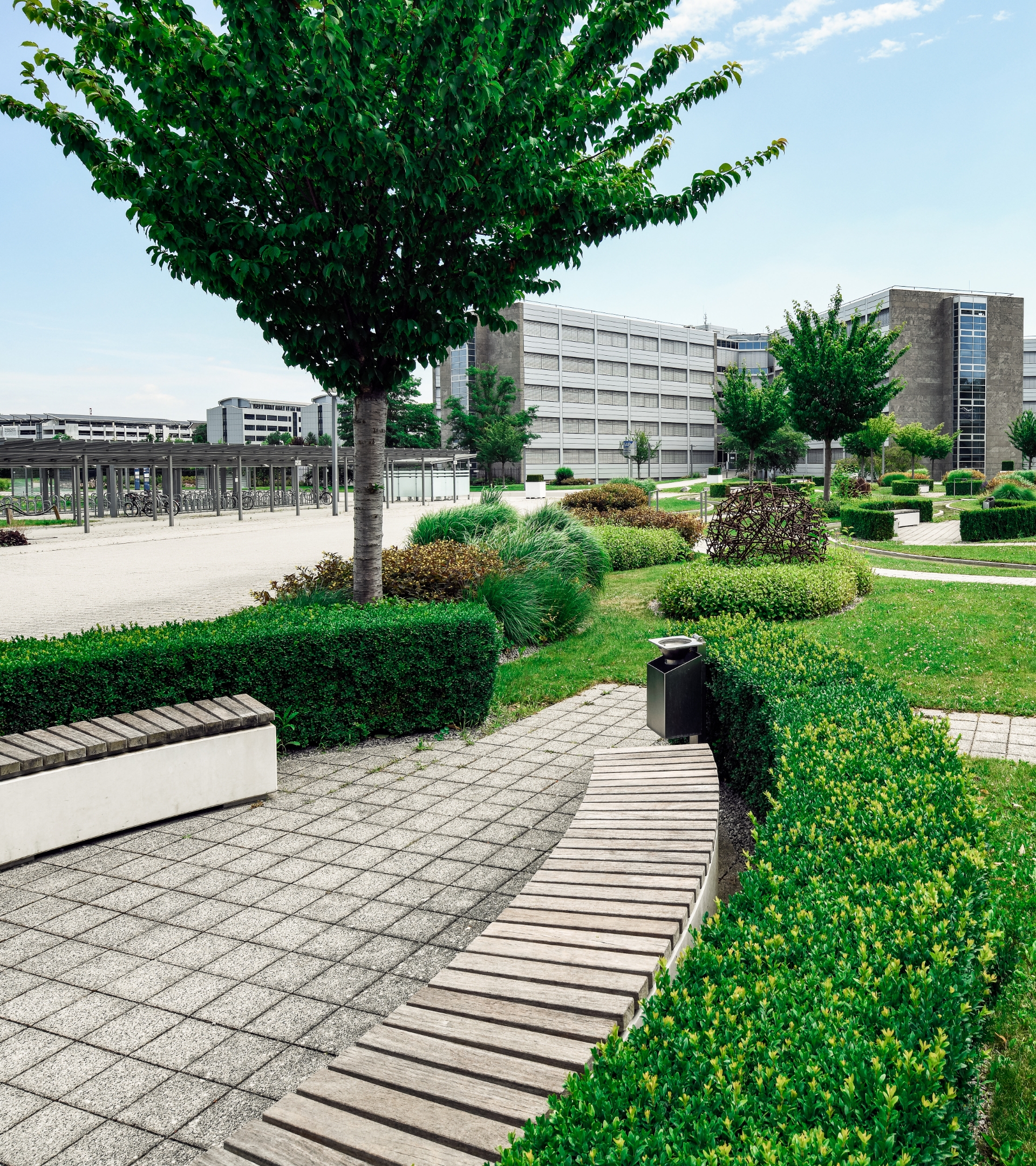 Blick auf die Grünanlagen der SAP in Wiesloch mit halbrunder Sitzgelegenheit aus Holz